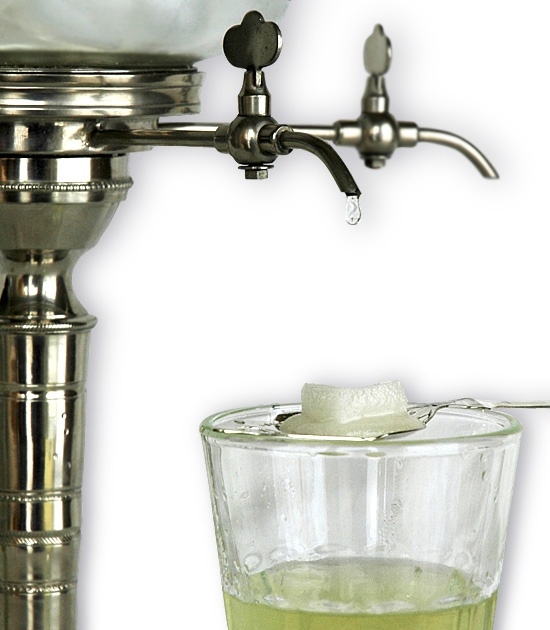Detail of Perigord Absinthe Glass with absinthe, sugar, spoon and traditional metal absinthe fountain.