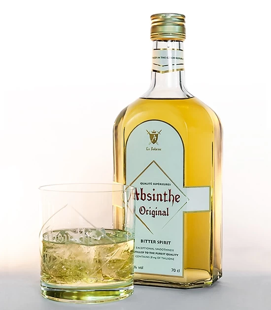 Heavy based short tumbler absinthe glass with absinthe on ice and bottle of Real Absinthe Original Bitter Spirit