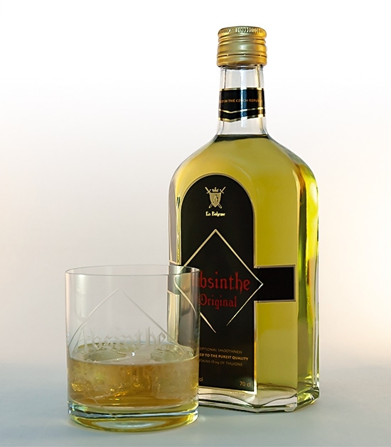 Glass of Fine Absinthe on Ice with lovely bottle of real Absinthe Original. Natural product with olive green color