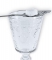 Detailed image of absinthe spoon on the rim of the glass with a cube of sugar set on top